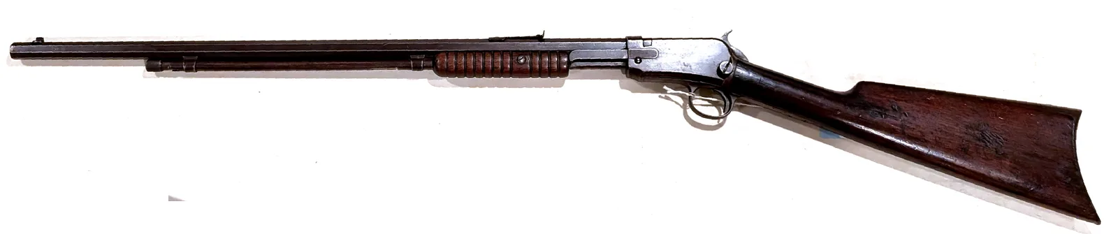 Winchester Model 1890 pump-action .22 takedown rifle, right side, on a white background.