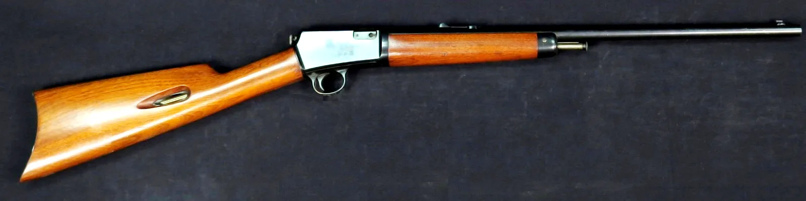 Winchester Model 1903 self-loading .22 rifle, left side, on a dark cloth.